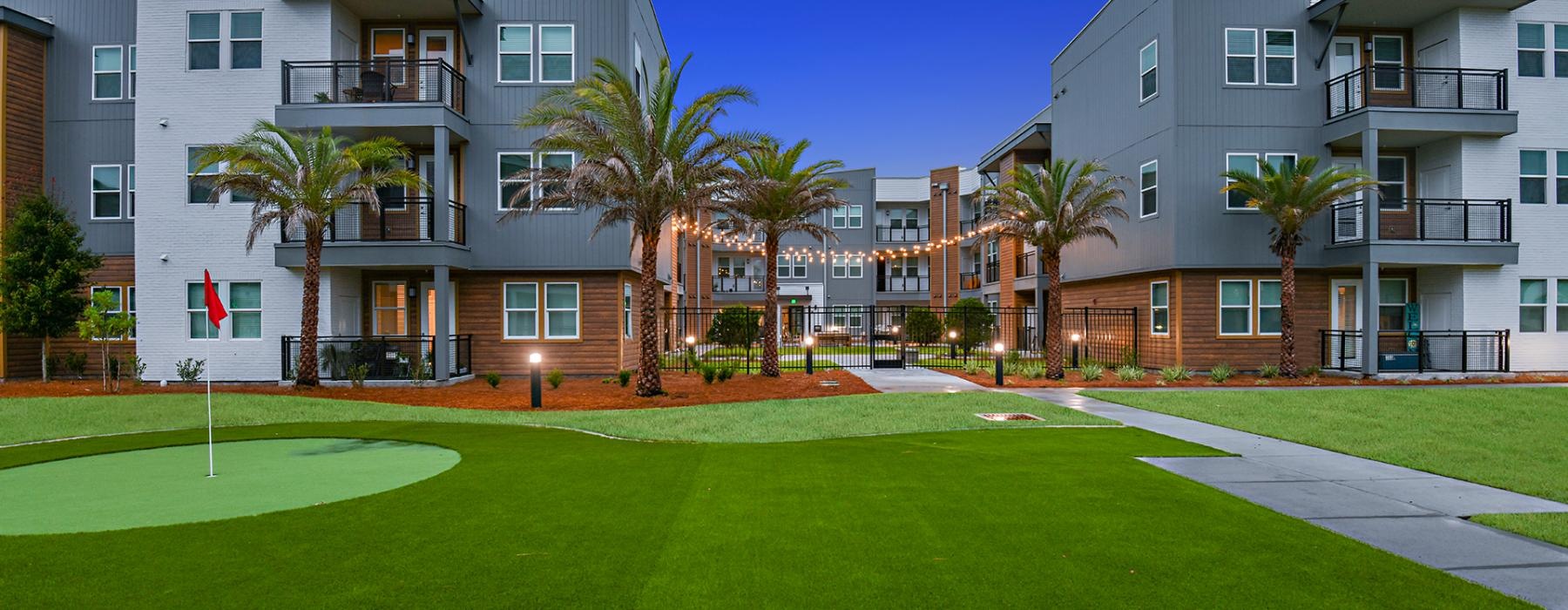 a building with palm trees and grass